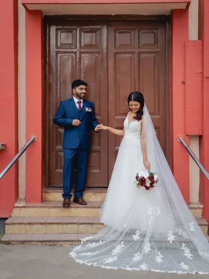 Another beautiful shot of the couple, showing the bride's elegant gown and veil. Her makeup is kept natural and radiant to let her happiness be the focus.