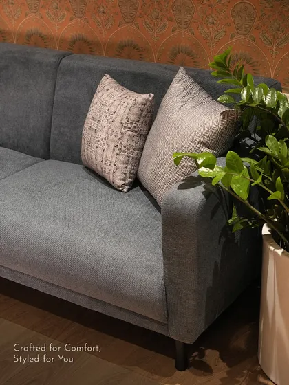 A close-up of a custom sofa, upholstered in a durable grey fabric. The clean lines and comfortable cushions make it a perfect piece for everyday living.