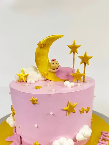 A closer look at the adorable sleeping baby and golden moon topper.