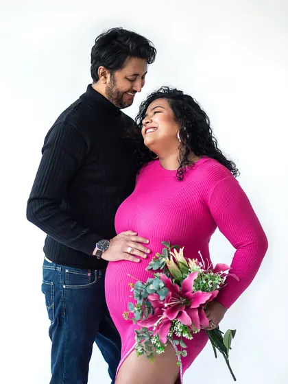 Adding a bouquet of flowers brings a touch of romance and softness to this modern maternity look.