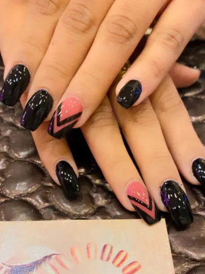 A bold and geometric design on square nails. This set combines glossy black nails with accent nails featuring a pink and black chevron pattern at the tip.