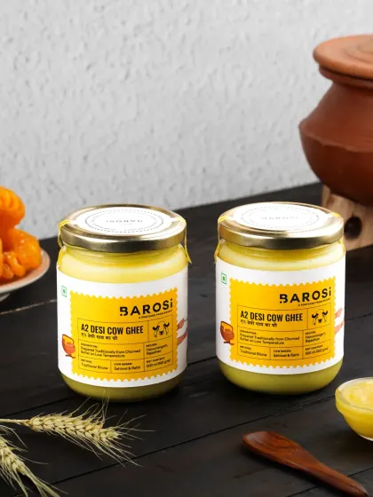 Two jars of A2 Desi Cow Ghee styled with a dark, rustic background, creating a moody and premium feel for the product.