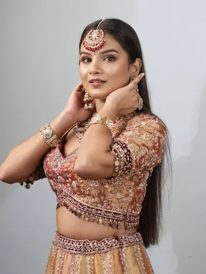 This pose highlights the soft contouring and the way the makeup complements the intricate jewellery, creating a balanced and elegant phera look.