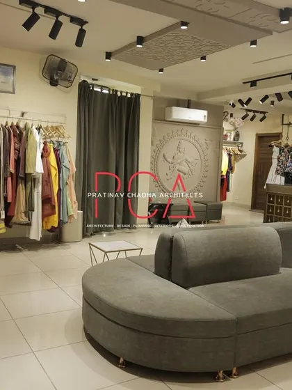 Another perspective of the Jubinav Chadha studio, showing the circular sofa and the arrangement of clothing displays to facilitate customer browsing.