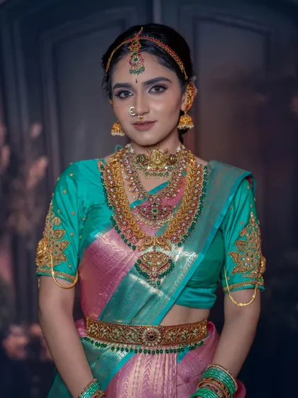 This look combines a beautiful teal and pink silk saree with antique-finish temple jewellery. I used a soft glam makeup technique to balance the vibrant colors of her outfit.