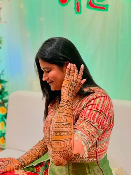 A candid shot of a bride admiring her intricate mehndi design during her ceremony.