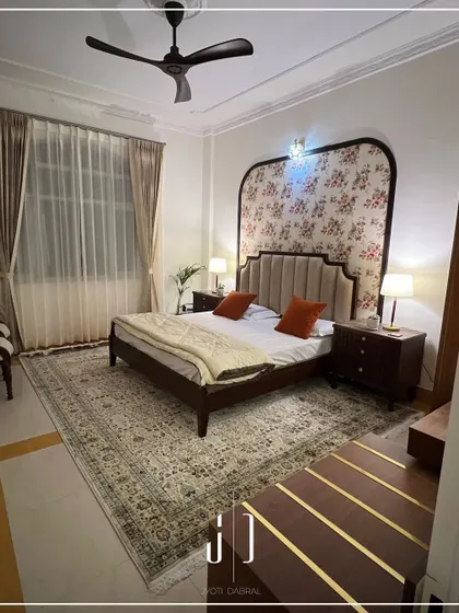 A look at one of the bedrooms we redesigned at the Jolly Grant Airport Guest House. The floral wallpaper behind the upholstered headboard creates a beautiful and serene focal point.