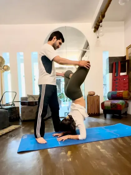 A different angle of the Lotus Forearm Balance assist, showing how I help stabilize the pelvis.