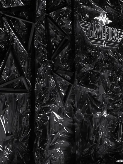 A 'Maverick' themed photo booth backdrop made from crumpled, reflective black material. We added a custom neon sign with the brand's logo to create a sharp, edgy look for this corporate event.