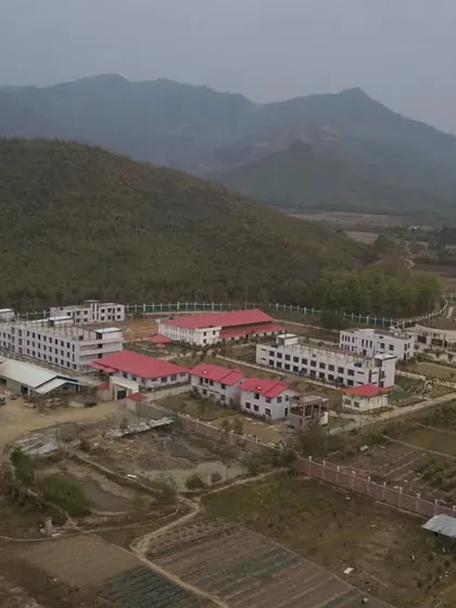 A real-world aerial view of the UNACCO School, showing the relationship between the completed buildings and the natural terrain we worked to preserve.