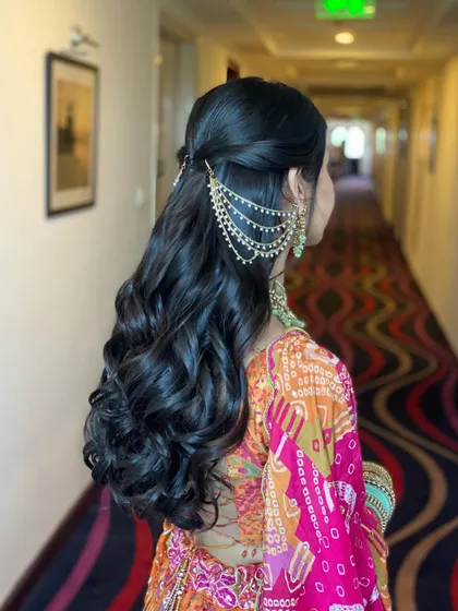 All set for her mehendi. This classic half-updo with soft curls is beautifully accessorized, and the extensions ensure her hair looks thick and healthy.