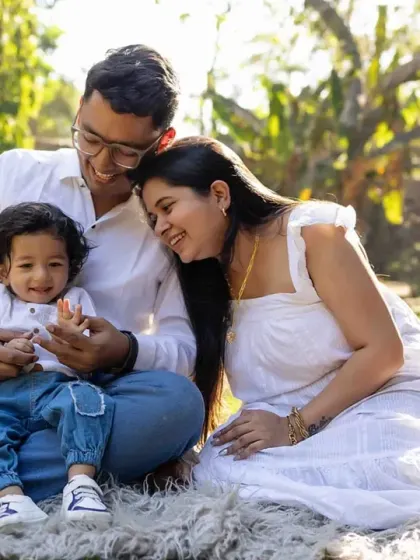 A sweet family cuddle in the park. The golden sunlight adds a magical glow to this loving portrait.