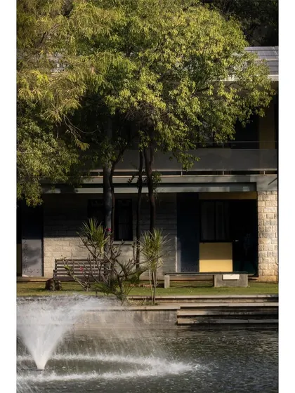 A view of the hospice across the water, framed by trees.