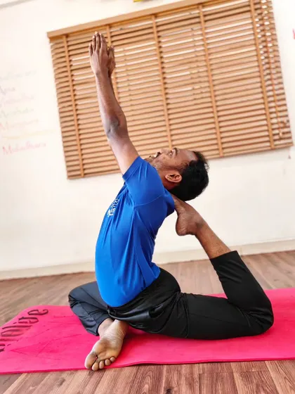 A student practices a variation of the King Pigeon Pose, working on opening the chest and shoulders.