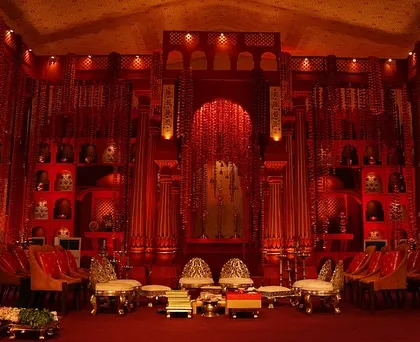 A wide view of the 'Lal Bagh' mandap, showing how we transformed an empty lawn into a majestic temple courtyard. The design includes grand pillars, intricate backdrops, and seating arranged for an immersive guest experience.