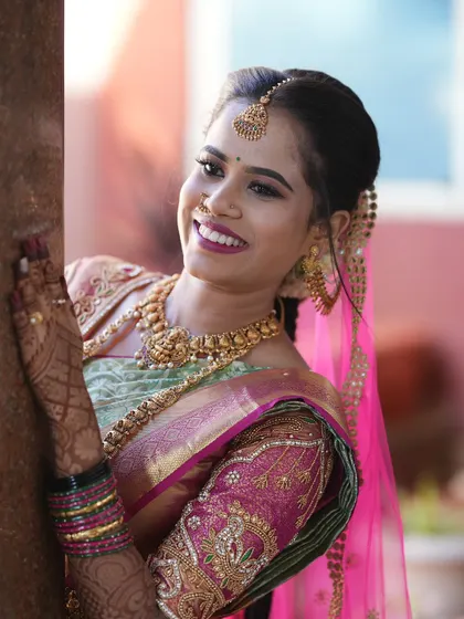 A classic bridal portrait of a smiling South Indian bride. I use natural light to highlight the intricate details of the wedding attire, from the silk saree to the temple jewelry.
