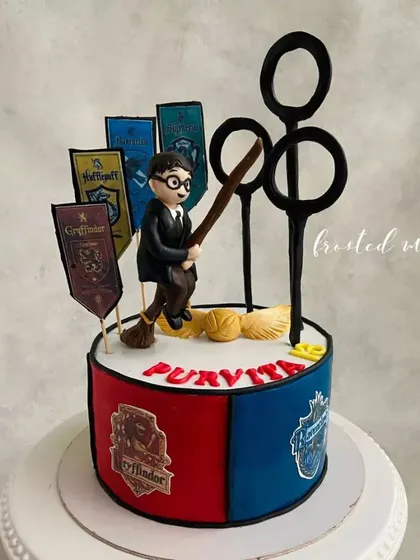 Calling all Potterheads! This Harry Potter themed cake features a hand-sculpted Harry on his broomstick, Quidditch hoops, and the house banners of Hogwarts. It's pure magic for a fan's birthday.
