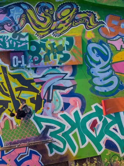 A detailed section of the collaborative mural at the skatepark, showing a collage of different styles and pieces from various artists.
