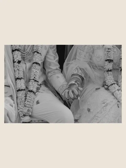 A black and white detail shot of the couple holding hands during the ceremony. This simple yet powerful image symbolizes their unity and the promises they are making to each other.