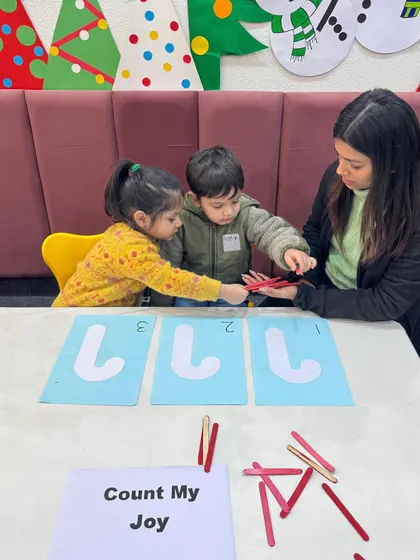Teamwork makes the dream work. These two children are helping each other place the correct number of sticks, learning both math and cooperation at the same time.