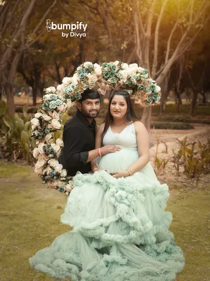 A circle of flowers for a circle of love. This outdoor maternity session uses a beautiful floral wreath prop to frame the glowing couple in a natural, park like setting.