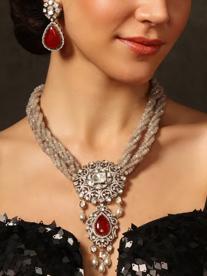 A sophisticated necklace with a polki and ruby pendant on a twisted string of grey beads, perfect for an elegant evening affair.