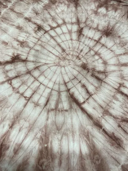 A beautiful spiral or 'spider web' pattern created through tie-dye. This technique involves twisting the fabric before dyeing to create radiating lines.