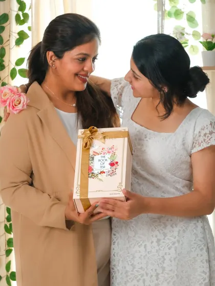 A tender moment of a daughter giving her mother a gift, capturing genuine affection and the joy of giving.