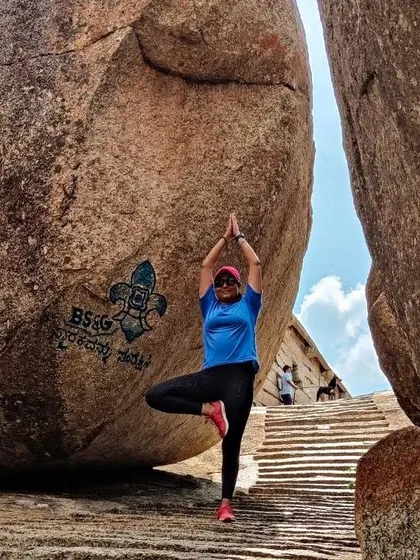 A moment of zen. A trekker practices a yoga pose between the giant boulders of Gudibande.