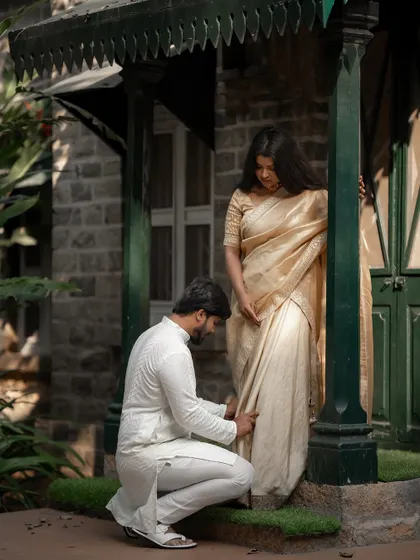 A tender moment of care in front of a classic stone house. This candid interaction, set against a timeless backdrop, speaks volumes about their relationship.