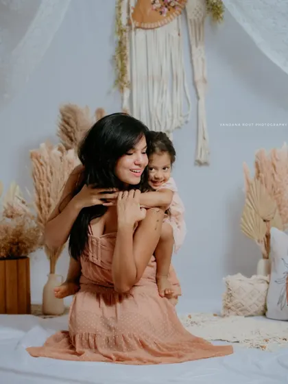 A mother gives her daughter a piggyback ride during their studio session. This playful and loving moment perfectly captures their special bond.