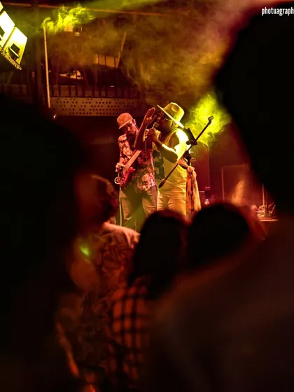 A peek at the stage through the crowd. It shows the intimate yet shared experience of a live gig.