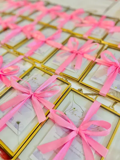 A full view of the brass photo frame and necklace favor, a truly special gift for wedding guests.