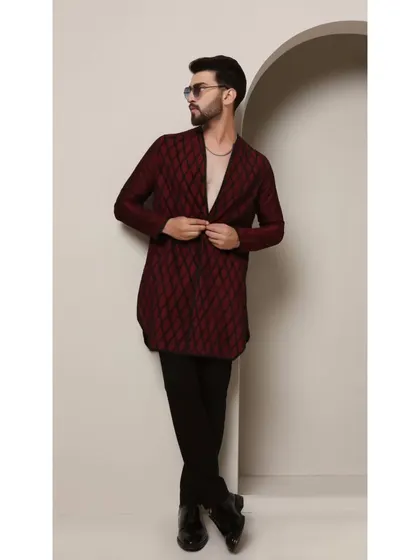 The 'Maroon Ragalia' kurta is designed for a man with a bold sense of style. The deep maroon fabric is textured with a diamond-cut pattern and black pintucks, creating a sophisticated and modern V-neck kurta.
