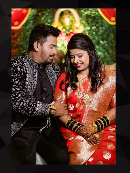 A lovely seated portrait of the couple at their reception. The groom gently holds his bride's hand, a simple, sweet gesture of their new life together.