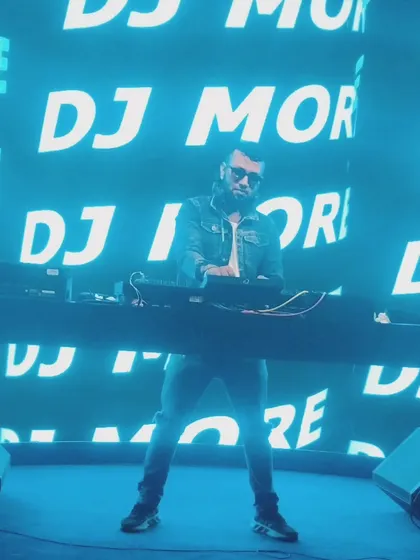 In my element, commanding the stage with my name up in lights. This is the energy and presence I bring to large-scale events, making sure every beat hits with maximum impact.