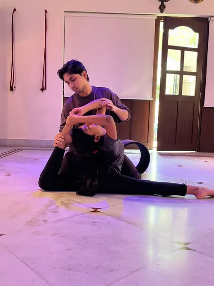 A close-up of the hands-on assistance I provide to ensure proper form during flexibility training.