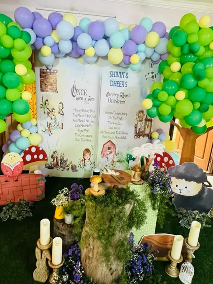 Welcome to Nursery Rhyme ONEderland. This enchanting main backdrop features beloved characters like Humpty Dumpty and the sheep from "Baa Baa Black Sheep," set in a whimsical forest scene.