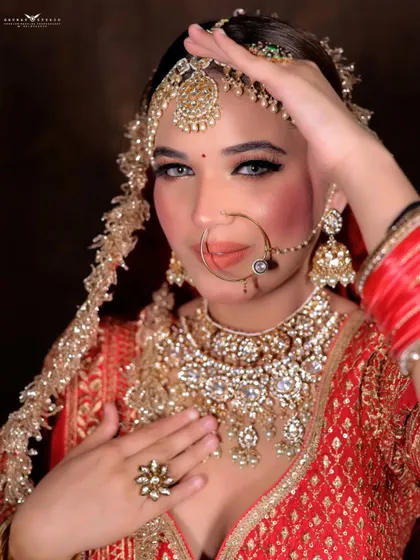 A graceful pose with the bride's hand on her forehead. This classic gesture adds a touch of drama and elegance to the bridal portrait.