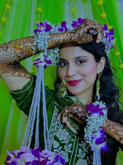 A stunning bride adorned with a floral crown and matching floral henna jewelry, perfectly complementing her intricate mehndi.
