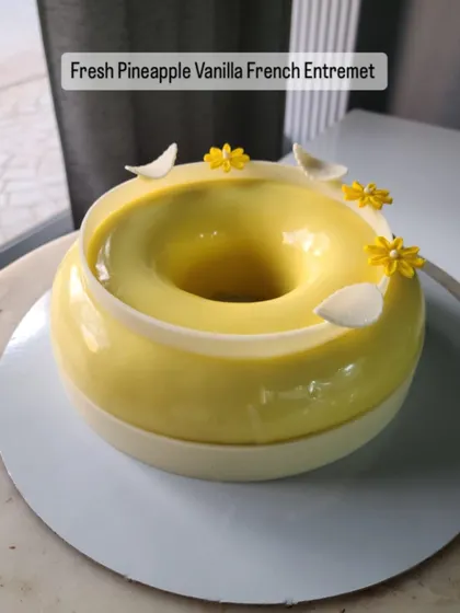 My Fresh Pineapple Vanilla French Entremet is a tropical dream. I infuse a fresh pineapple compote with star anise and pair it with a light vanilla mousse and soft vanilla sponge. It is finished with handcrafted chocolate feathers and edible flowers.