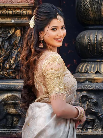 A side profile showcasing the elegant hairstyle and intricate gold embroidery on the blouse. We believe in creating a complete, cohesive look from every angle.