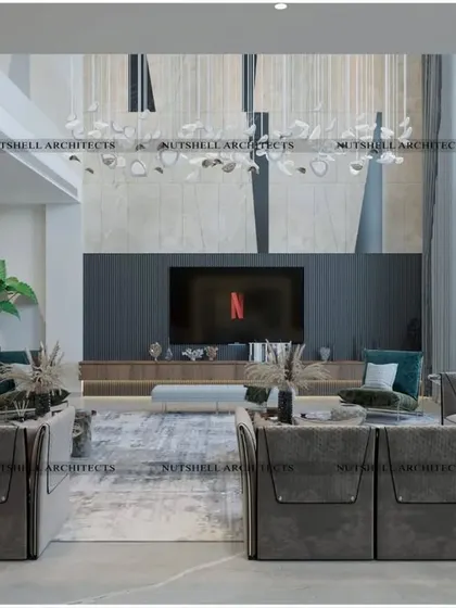 A double-height living room designed for ultimate comfort. The large, modular sofa provides ample seating, while the towering TV wall and dramatic chandelier draw the eye upwards, emphasizing the grand scale of the space.