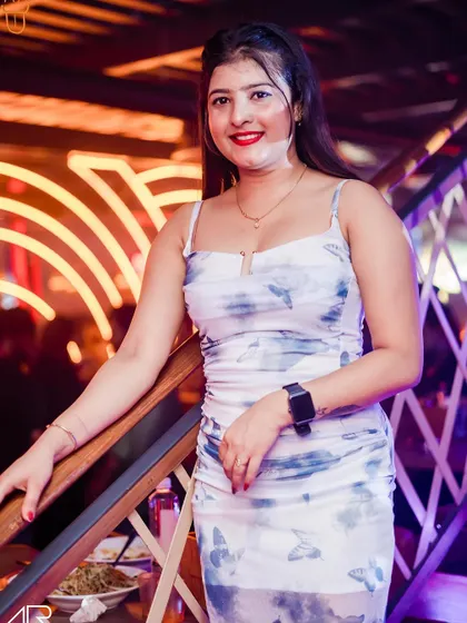 A guest looking lovely in a blue and white dress, enjoying the club's ambiance.