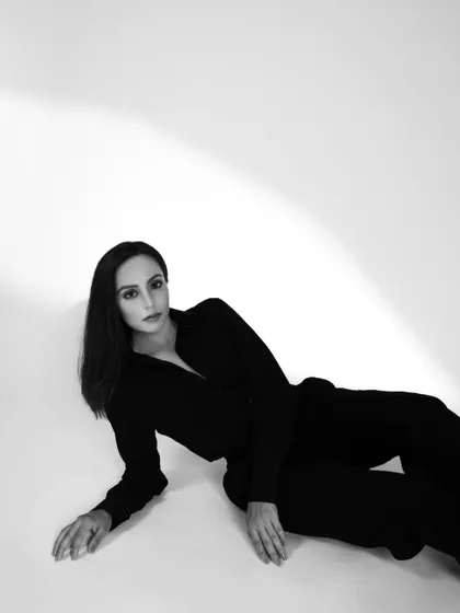 A minimalist and elegant black and white fashion portrait. The clean composition and soft lighting create a sophisticated and timeless feel.