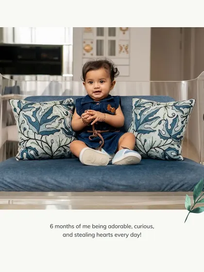 A candid moment from a six-month milestone session at home. Sometimes the simplest moments, like sitting on a small sofa, make for the most adorable and natural portraits.
