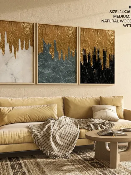 Our triptych of gold foil and marble abstract prints, shown here in a living room with warm, neutral tones. The natural wood frames with glass add a classic touch to the glamorous artwork.