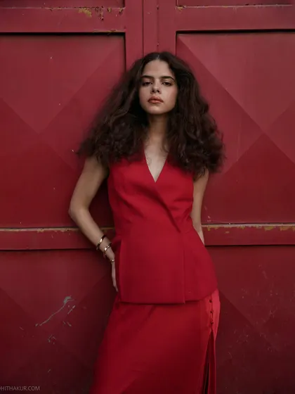 The power of a bold color. This all-red outfit against a red door creates a stunning monochromatic look that is both elegant and fierce.