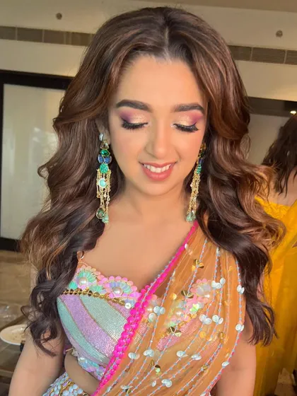 A close-up of the eye makeup, showing the beautiful blend of pink and gold shimmer. It's a playful yet elegant look for a Mehendi ceremony.