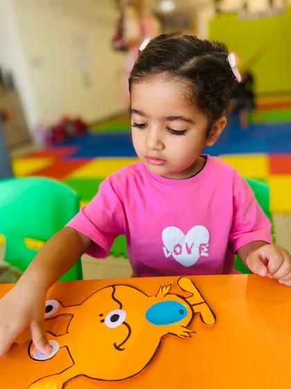 A young girl works on her own unique alien creation. We encourage individuality and personal expression in all our art projects.